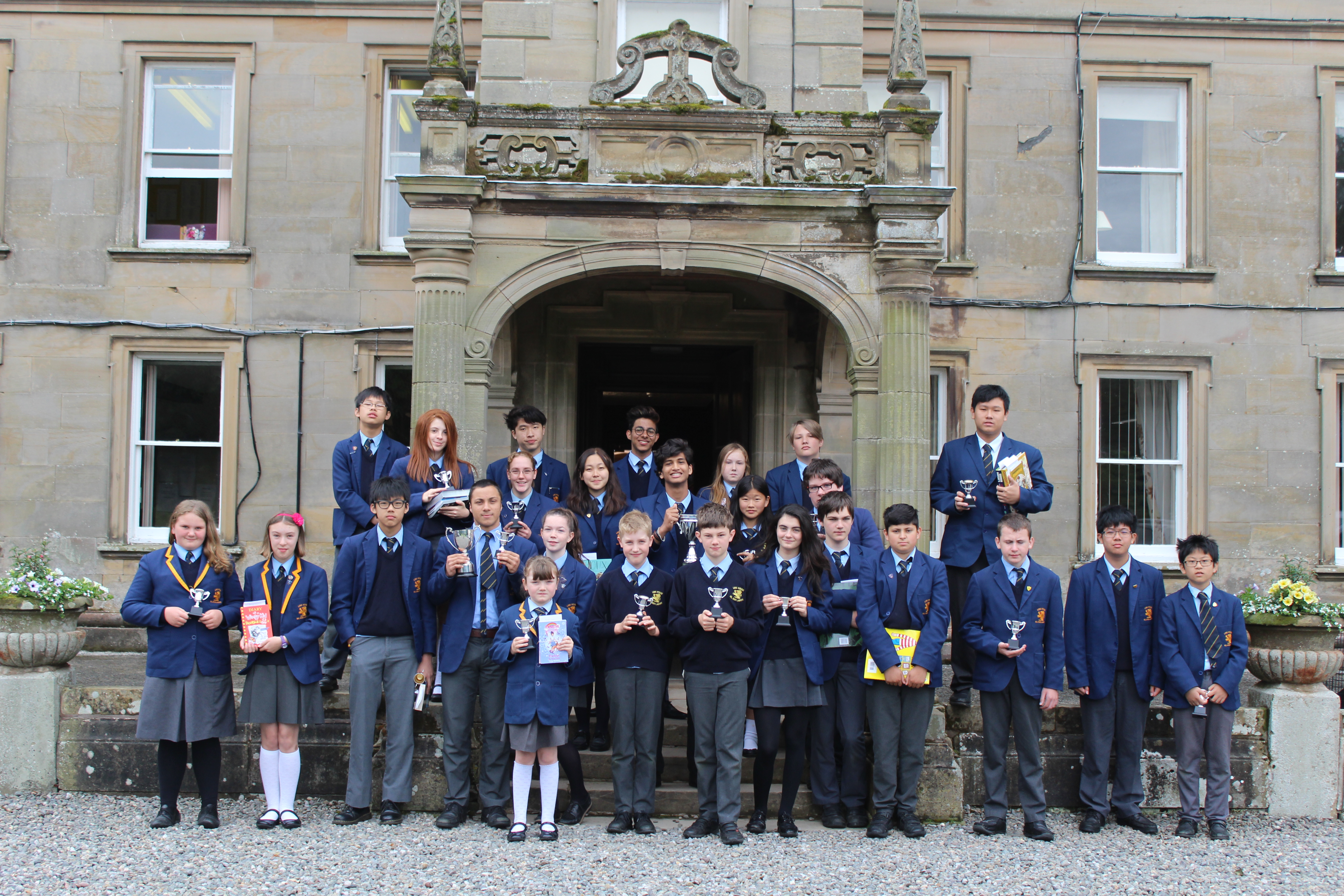 UK Boarding School students outside of a British Boarding School holding awards